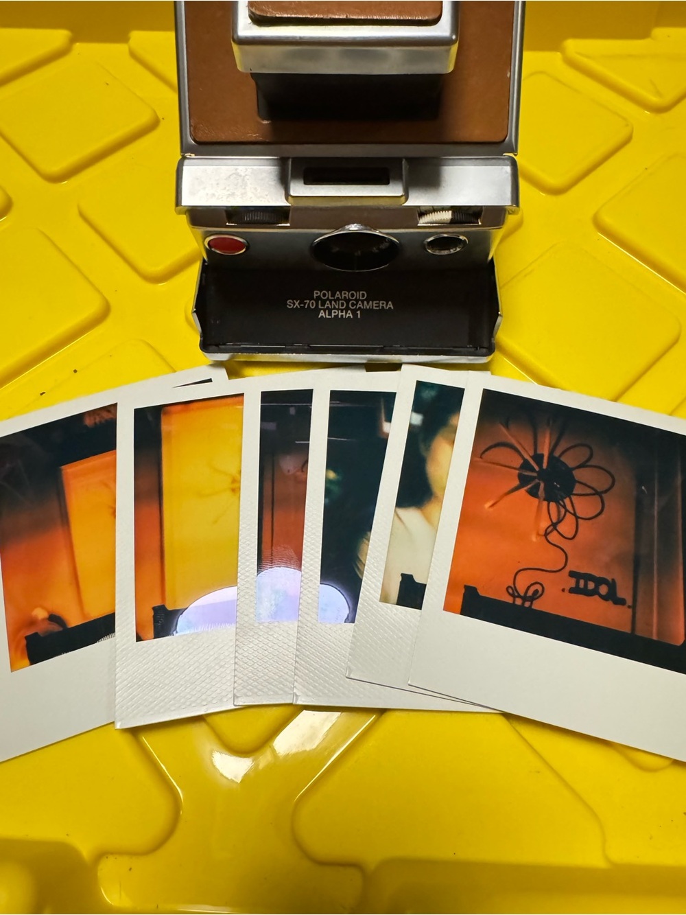 Polaroid SX-70 Instant Camera in Brown and Silver with Colorful Prints